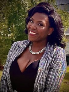 Confident woman smiling outdoors in stylish attire and pearl necklace.