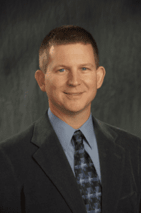 Professional headshot of a man in a suit and tie.