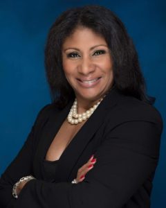 Confident professional woman in business attire with pearl necklace.
