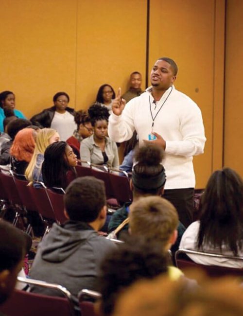 Speaker addressing a group of students.